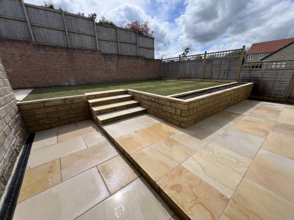Finished Project Photo: Functional Stonemasonry, retaining feature contains retaining walls and steps with integrated planters, stone matched to the property for a cohesive minimal design showcasing our Stonemasonry & Landscaping Services in Leeds & West Yorkshire