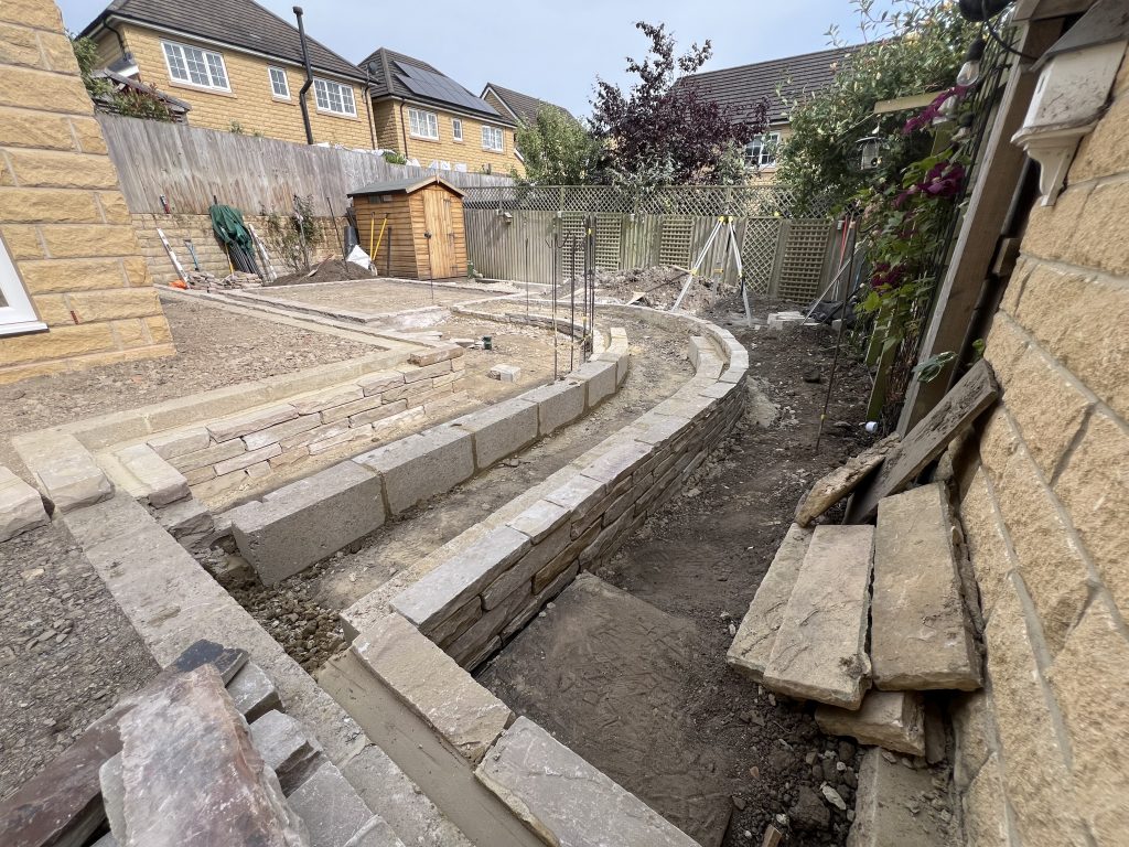 Drystone effect curved sloped wheelchair access path, built in sandstone: Showcasing our bespoke Stonemasonry in Leeds & West Yorkshire.