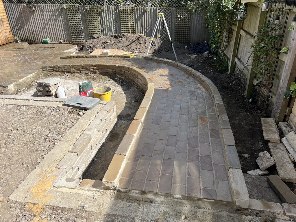 Drystone effect curved sloped wheelchair access path, built in sandstone, surfaced with traditional  sandstone cobbles: Showcasing our bespoke Stonemasonry in Leeds & West Yorkshire.